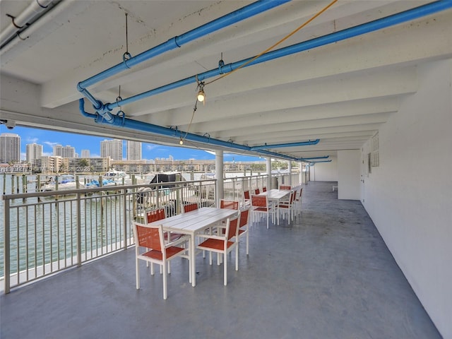 view of patio / terrace with a view of city, a water view, and outdoor dining space