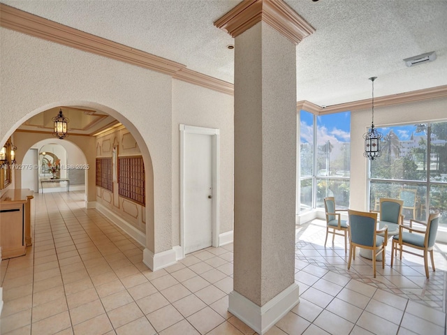 interior space featuring an inviting chandelier, arched walkways, and ornamental molding