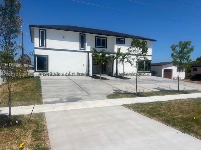 view of front of house with a garage, stucco siding, and concrete driveway