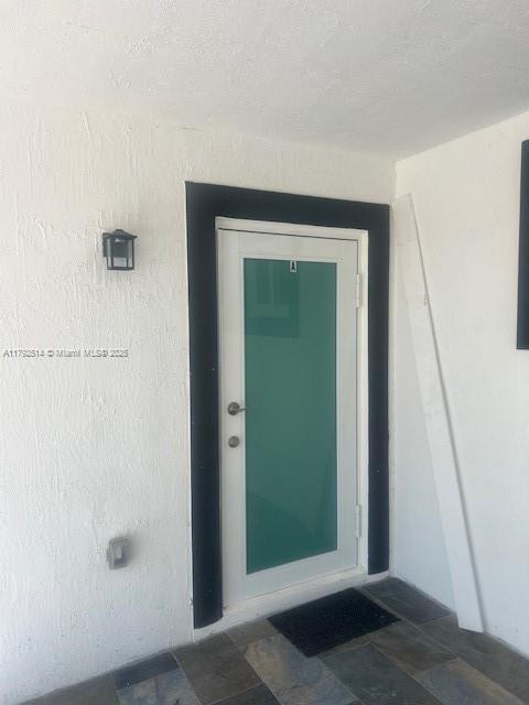 property entrance with stucco siding