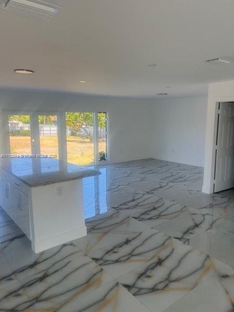 unfurnished room with marble finish floor and visible vents