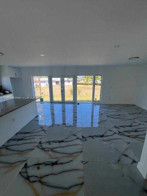 unfurnished room featuring recessed lighting, marble finish floor, a healthy amount of sunlight, and french doors