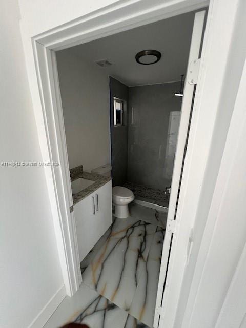 bathroom with vanity, a stall shower, and toilet