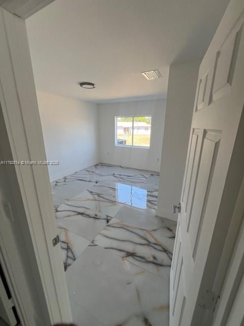spare room featuring marble finish floor and visible vents