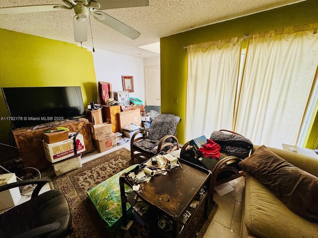 living area with ceiling fan and a textured ceiling