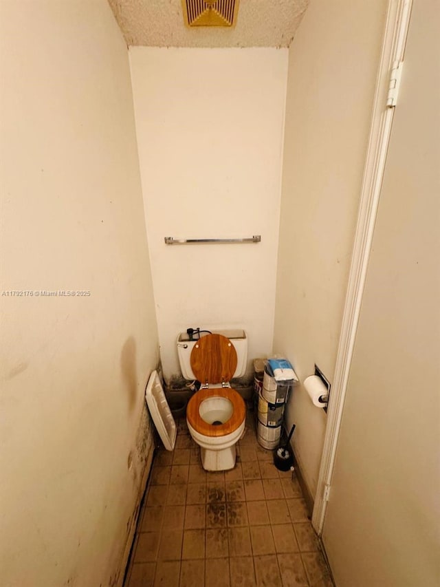 bathroom with tile patterned flooring, visible vents, and toilet
