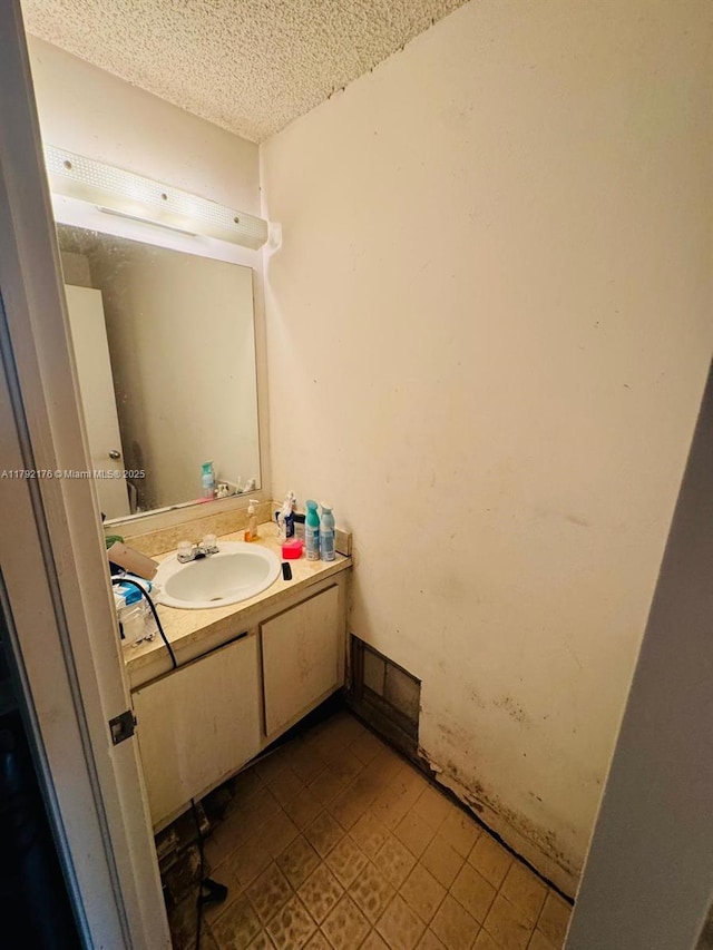 bathroom with vanity, a textured ceiling, and tile patterned flooring