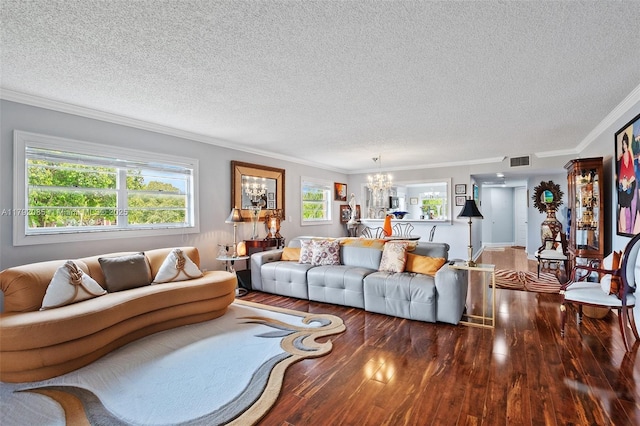 living area with a textured ceiling, visible vents, wood finished floors, a chandelier, and ornamental molding