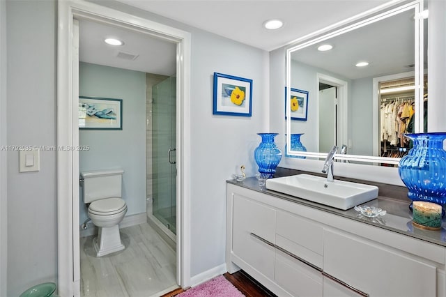 bathroom featuring a stall shower, vanity, baseboards, toilet, and recessed lighting