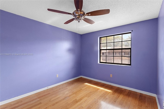 unfurnished room featuring a textured ceiling, baseboards, a ceiling fan, and wood finished floors