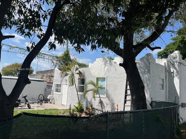 view of side of property featuring stucco siding and fence