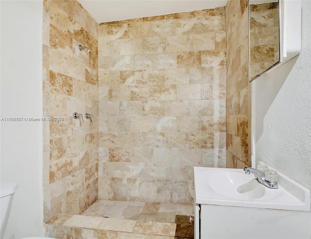full bathroom with vanity, a tile shower, and toilet