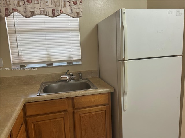 2900 N Pine Island Rd Unit 307, Sunrise, FL 33322 - kitchen featuring freestanding refrigerator, brown cabinetry, and a sink