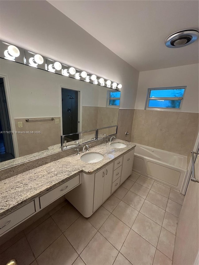 bathroom featuring a sink, tile patterned flooring, and a washtub