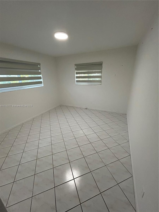unfurnished room featuring light tile patterned flooring and a wealth of natural light