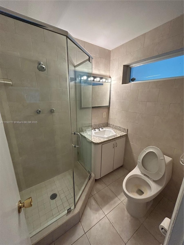 bathroom with tile patterned flooring, vanity, toilet, and a shower stall