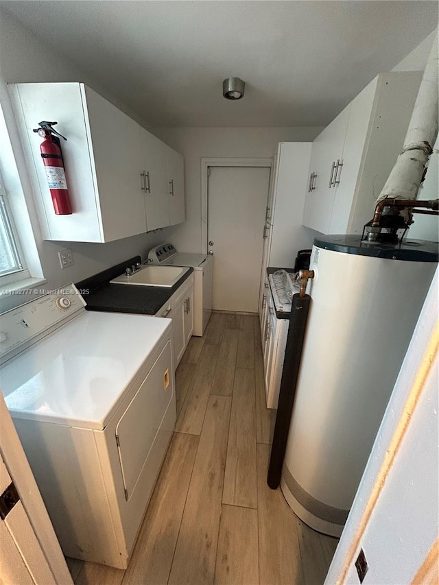 kitchen featuring white cabinets, a sink, light wood finished floors, and water heater