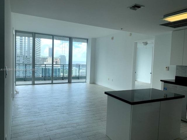 92 SW 3rd St Unit 3903, Miami, FL 33130 - interior space featuring a kitchen island, visible vents, dark countertops, white cabinetry, and light wood-style flooring