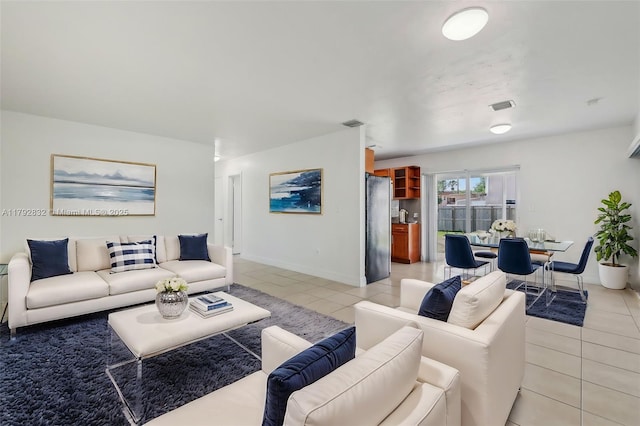 living area featuring light tile patterned floors, baseboards, and visible vents
