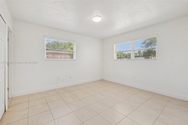 unfurnished room with baseboards and a wealth of natural light