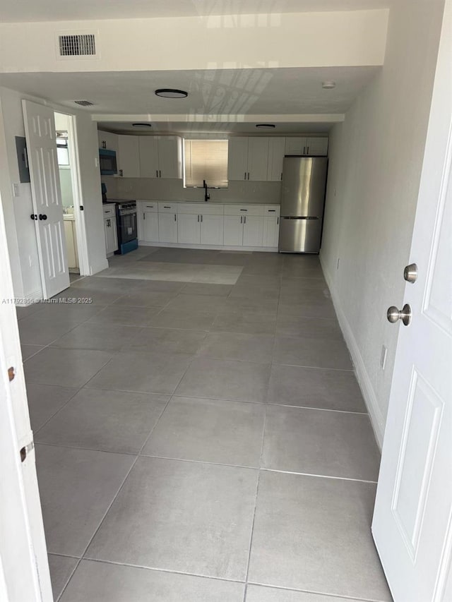 2291 W 53rd Pl Unit 2291, Hialeah, FL 33016 - garage with a sink, baseboards, freestanding refrigerator, and visible vents
