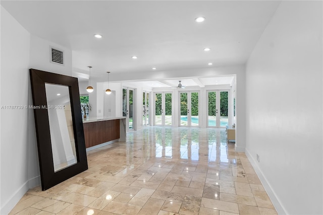 interior space featuring baseboards, visible vents, ceiling fan, and open floor plan