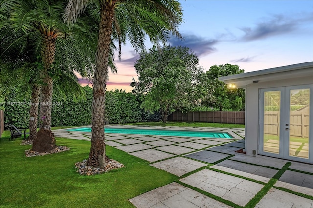 view of pool with a fenced backyard, french doors, a fenced in pool, a patio area, and a yard