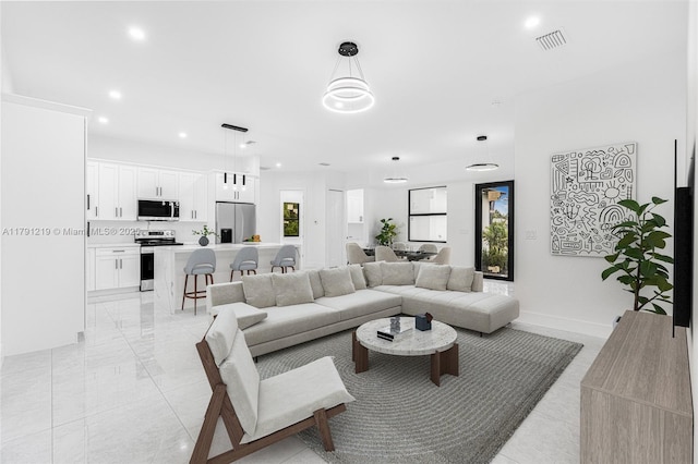living room featuring recessed lighting, baseboards, a wealth of natural light, and visible vents