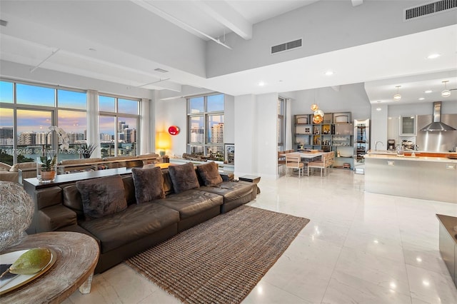 living room featuring visible vents, a wealth of natural light, and a city view