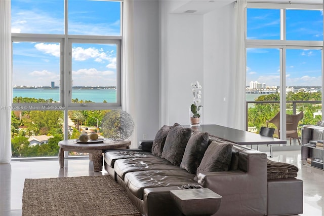 tiled living area featuring a water view, floor to ceiling windows, and a city view