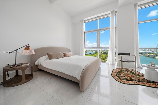 bedroom with multiple windows and marble finish floor
