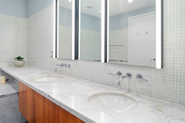 full bath with double vanity, a sink, and backsplash