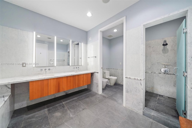 bathroom featuring a sink, a bidet, a shower stall, and tile walls