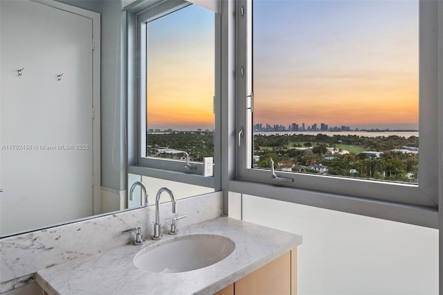 bathroom with a view of city, plenty of natural light, and vanity