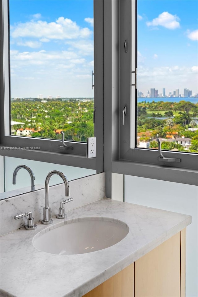 bathroom with a healthy amount of sunlight, a city view, and vanity