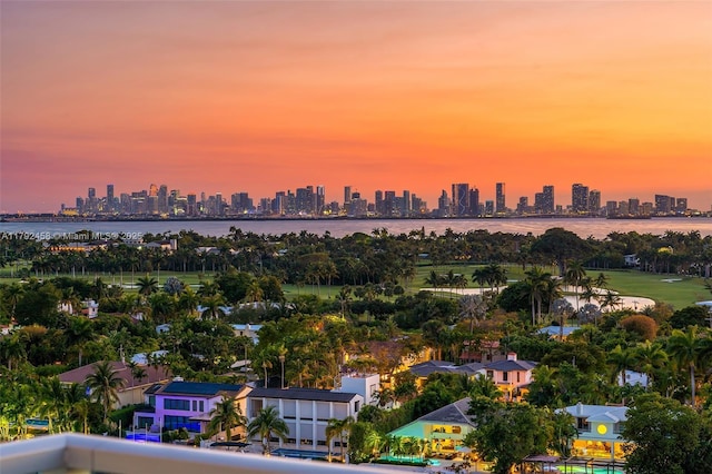 aerial view at dusk with a city view and a water view