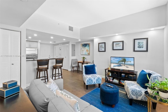 living area with visible vents, recessed lighting, baseboards, and wood finished floors