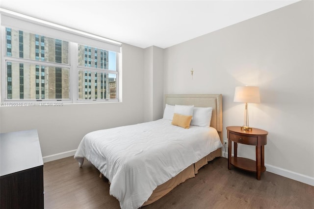bedroom with baseboards and wood finished floors