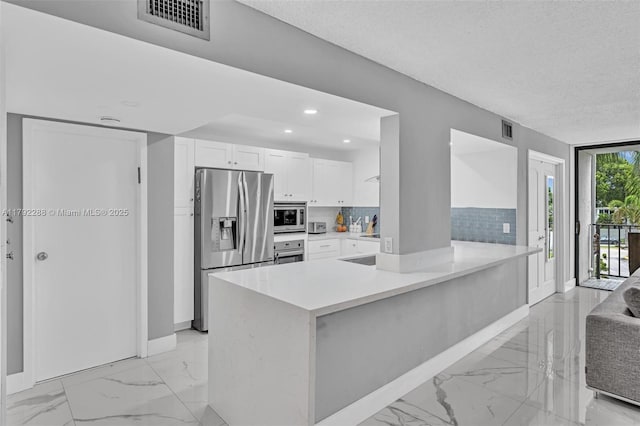 1000 Parkview Dr Unit 329, Hallandale Beach, FL 33009 - kitchen with visible vents, marble finish floor, white cabinetry, backsplash, and stainless steel appliances