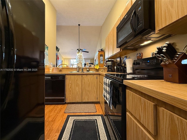 kitchen with ceiling fan, a sink, light wood-style floors, wooden counters, and black appliances