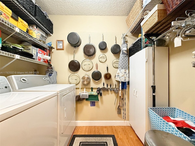 washroom featuring laundry area, baseboards, light wood-style floors, and washing machine and dryer