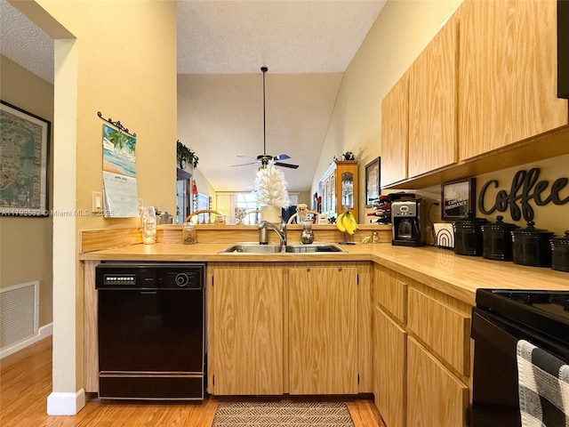 kitchen with a sink, light wood-style flooring, a peninsula, visible vents, and black appliances