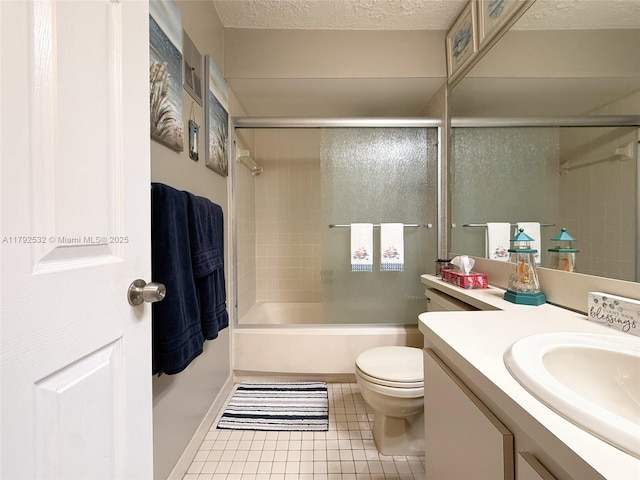 bathroom with tile patterned flooring, vanity, shower / bath combination with glass door, toilet, and a textured ceiling
