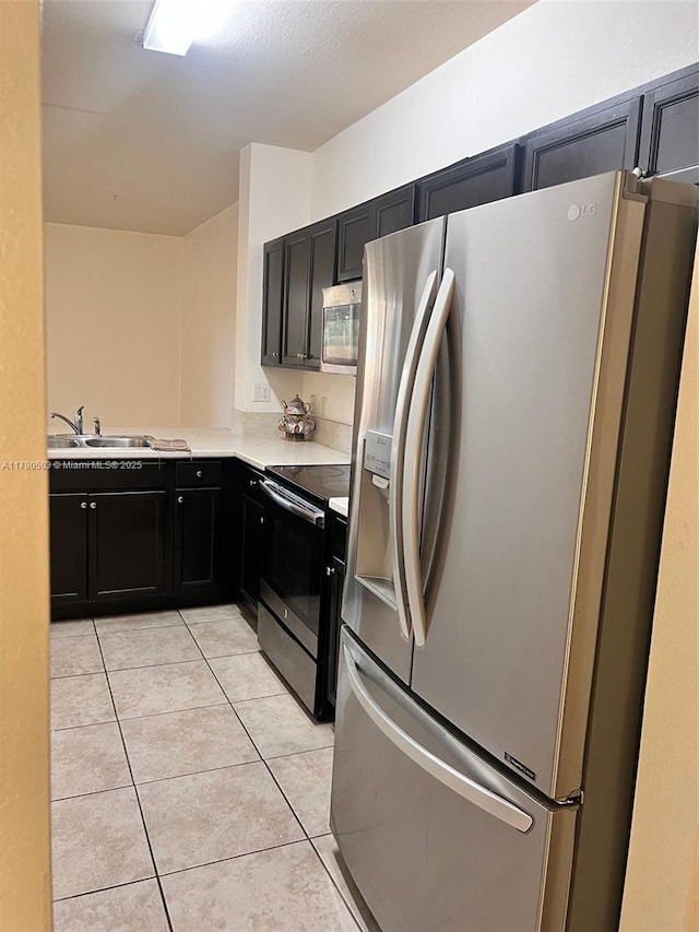 112 SE 28th Ter Unit 4, Homestead, FL 33033 - kitchen with light countertops, dark cabinets, a sink, appliances with stainless steel finishes, and light tile patterned floors