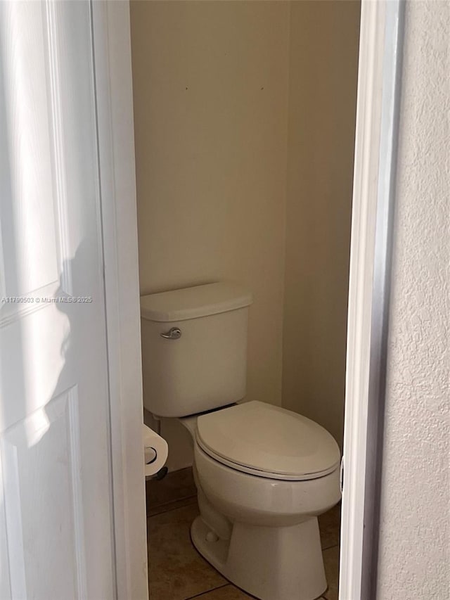 112 SE 28th Ter Unit 4, Homestead, FL 33033 - bathroom featuring tile patterned floors, a textured wall, and toilet