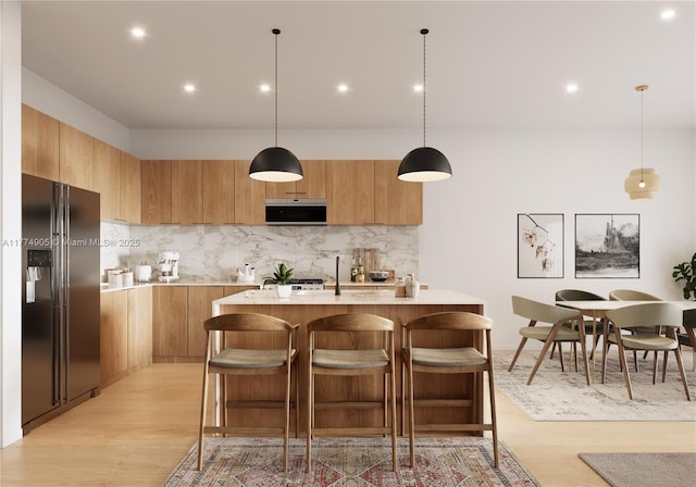 kitchen with light countertops, fridge with ice dispenser, modern cabinets, and tasteful backsplash