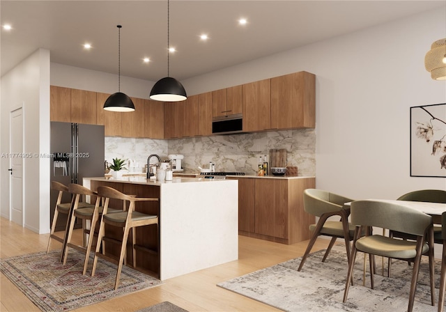 kitchen featuring brown cabinetry, modern cabinets, an island with sink, light countertops, and stainless steel appliances