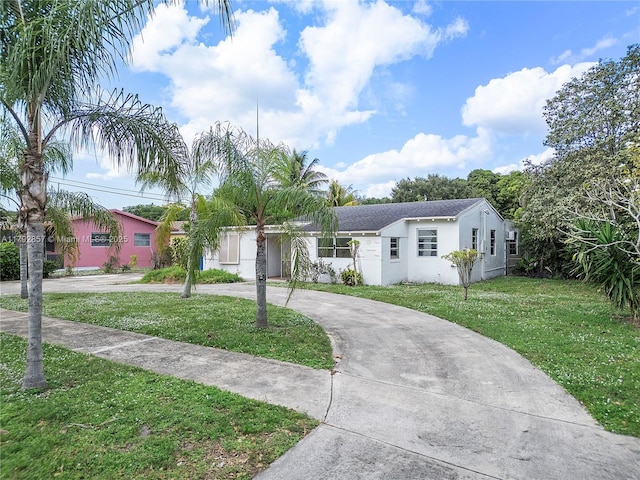 5709 Mckinley St, Hollywood, FL 33021 - ranch-style house featuring curved driveway, stucco siding, and a front yard