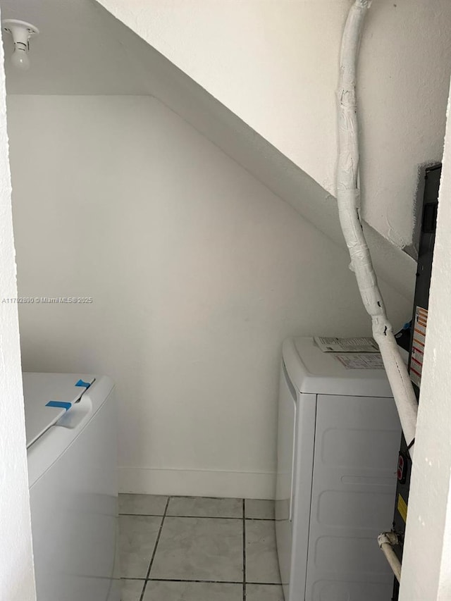 washroom with tile patterned flooring, laundry area, baseboards, and washer / clothes dryer