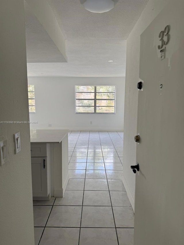 hall with light tile patterned floors and baseboards